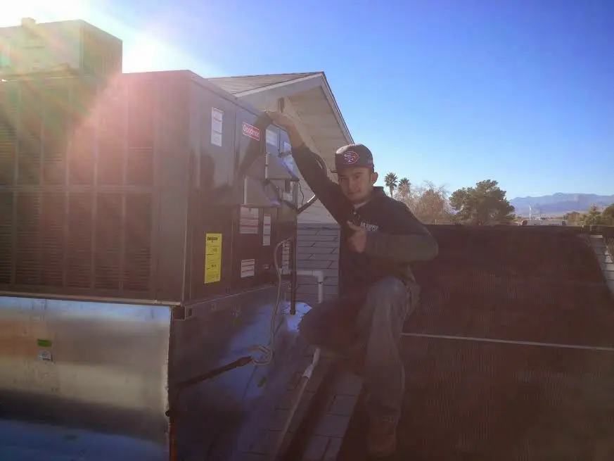 HVAC technician performing Air Duct Cleaning on a rooftop unit in Southchase